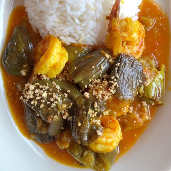 Burmese shrimp and eggplant curry with white rice, garnished with crushed peanuts.